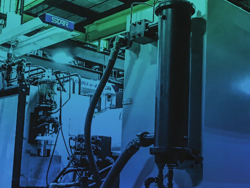 Injection moulding machine with hydraulic pipework and a large vertical cylinder