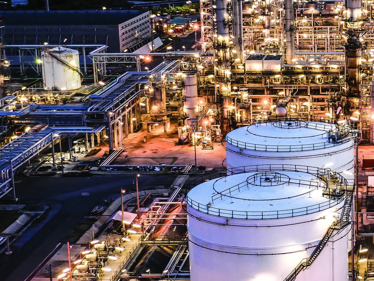 Refinery process equipment and storage tanks illuminated at dusk
