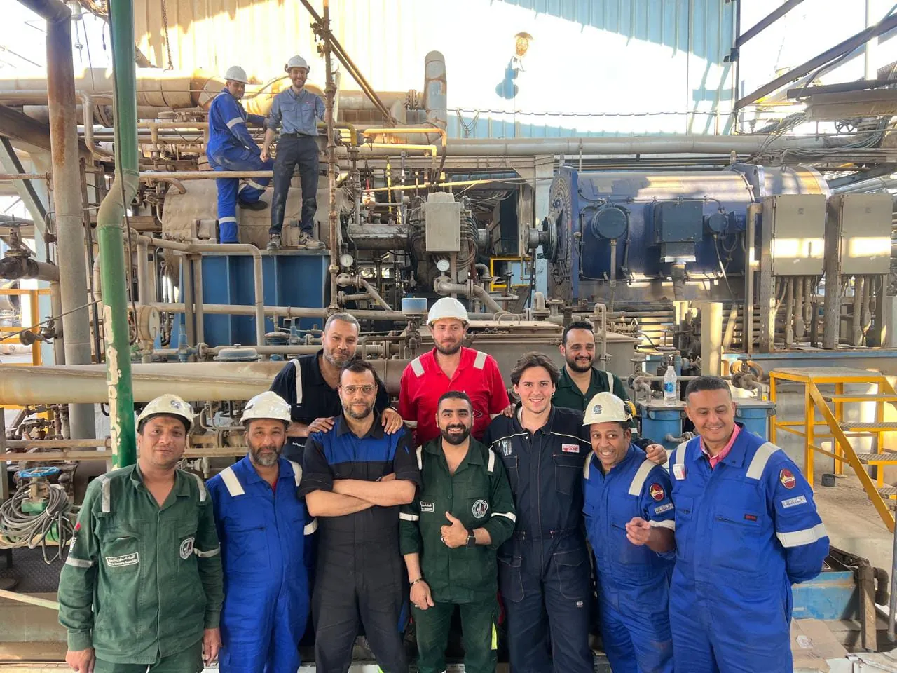 Project team members gathered beside the Hydrogen Recycle Gas Compressor at CORC